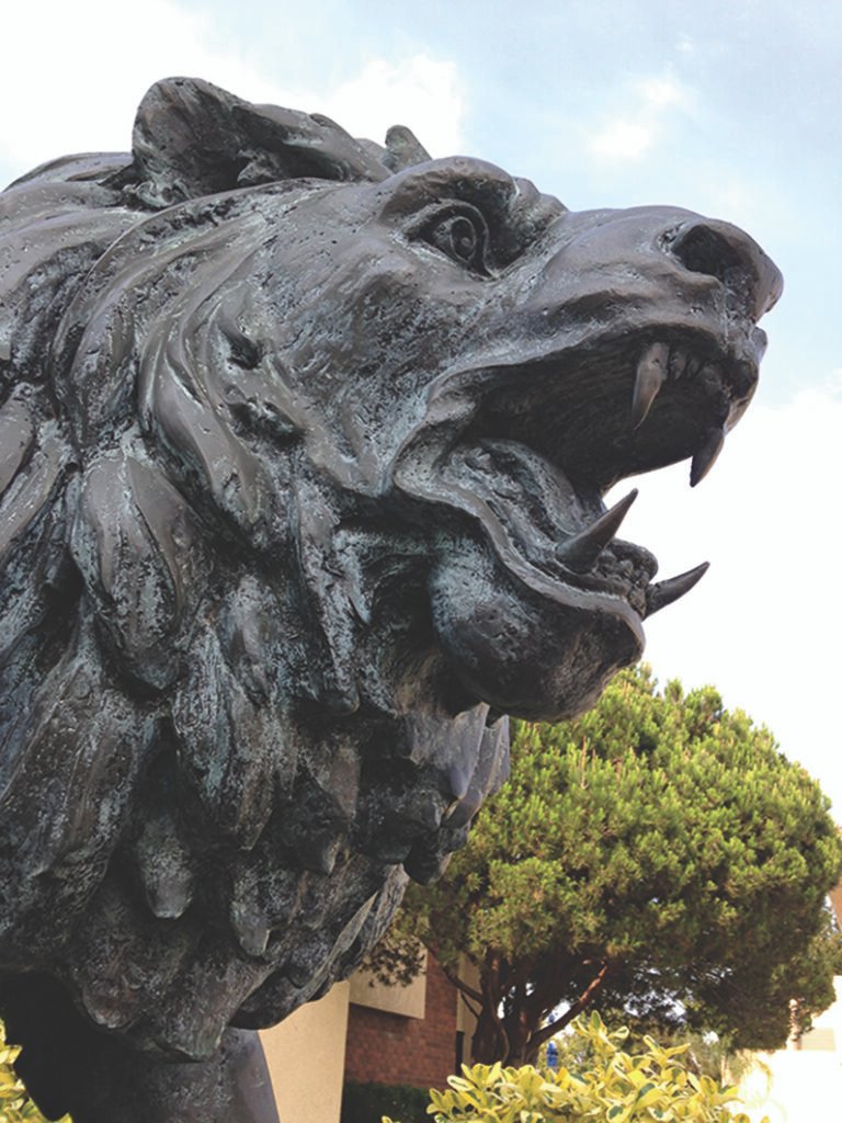 A bronze statue of a lion roaring