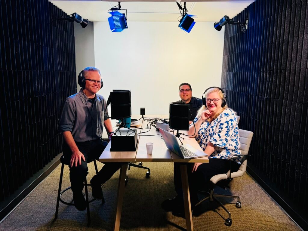 Three colleagues record in a podcast suite together